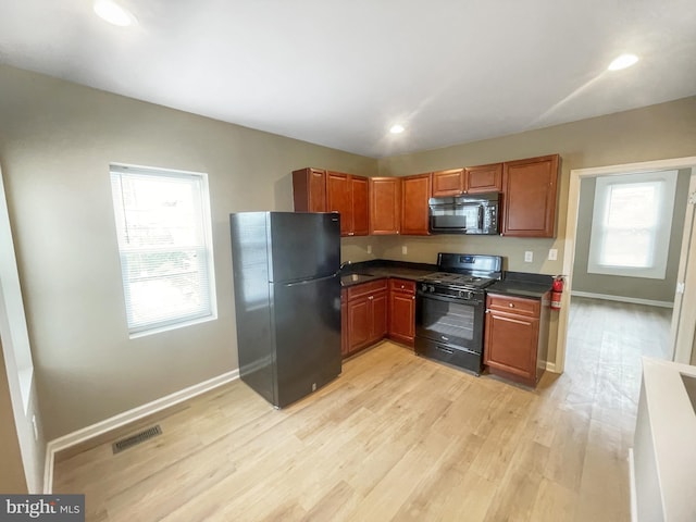 978 N 45th St, Philadelphia, PA 19104 - kitchen featuring black appliances, dark countertops, light wood-style flooring, healthy amount of natural light, and recessed lighting