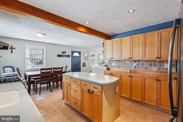 228 Balligomingo Rd, Conshohocken, PA 19428 - kitchen with a textured ceiling, light countertops, a center island, decorative backsplash, and freestanding refrigerator