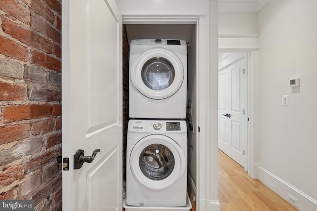 408 M St NW Unit 4, Washington, DC 20001 - laundry room with stacked washer / drying machine, light wood-style floors, brick wall, and baseboards