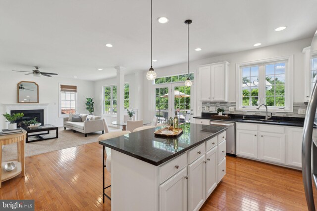 42322 Rising Moon Pl, Brambleton, VA 20148 - kitchen with stainless steel dishwasher, a sink, a ceiling fan, white cabinets, and a kitchen bar