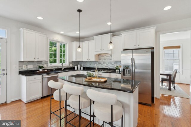 42322 Rising Moon Pl, Brambleton, VA 20148 - kitchen featuring stainless steel appliances, white cabinetry, backsplash, light wood-style floors, and recessed lighting