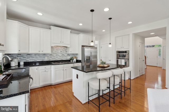 42322 Rising Moon Pl, Brambleton, VA 20148 - kitchen with appliances with stainless steel finishes, a sink, decorative backsplash, white cabinets, and recessed lighting