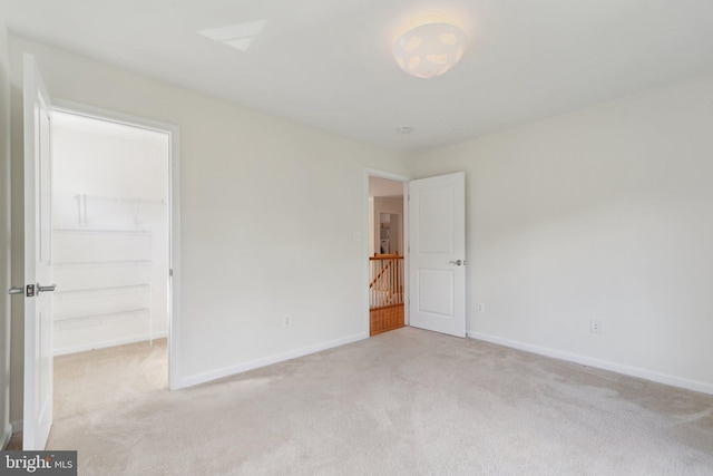 42322 Rising Moon Pl, Brambleton, VA 20148 - unfurnished bedroom featuring light carpet, a walk in closet, and baseboards