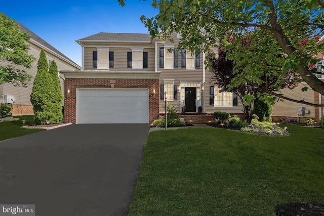 42322 Rising Moon Pl, Brambleton, VA 20148 - view of front of home with an attached garage, asphalt driveway, a front yard, and brick siding