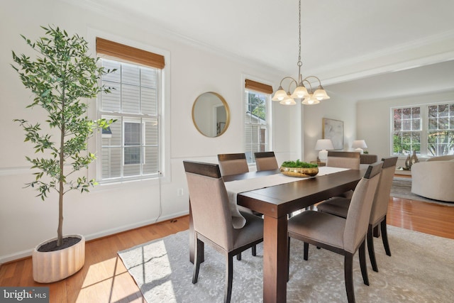 42322 Rising Moon Pl, Brambleton, VA 20148 - dining room with a chandelier, healthy amount of natural light, crown molding, light wood finished floors, and baseboards