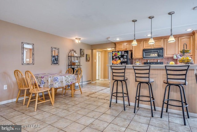 691 Harvey St, West Hazleton, PA 18202 - kitchen featuring black appliances, a kitchen breakfast bar, tasteful backsplash, decorative light fixtures, and baseboards