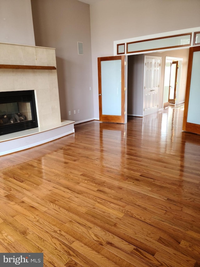364 Swedesboro Rd, Mullica Hill, NJ 08062 - unfurnished living room with wood finished floors, a towering ceiling, baseboards, and a fireplace