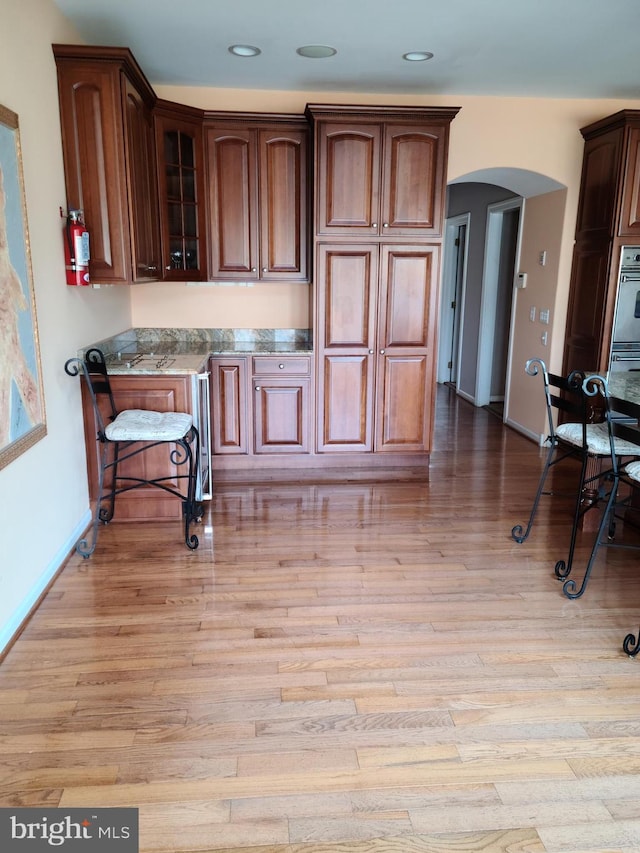 364 Swedesboro Rd, Mullica Hill, NJ 08062 - kitchen with arched walkways, light wood-style floors, glass insert cabinets, baseboards, and recessed lighting