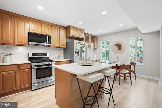 5050 7th Rd S Unit 201, Arlington, VA 22204 - kitchen featuring stainless steel appliances, light countertops, a kitchen bar, light wood-type flooring, and recessed lighting