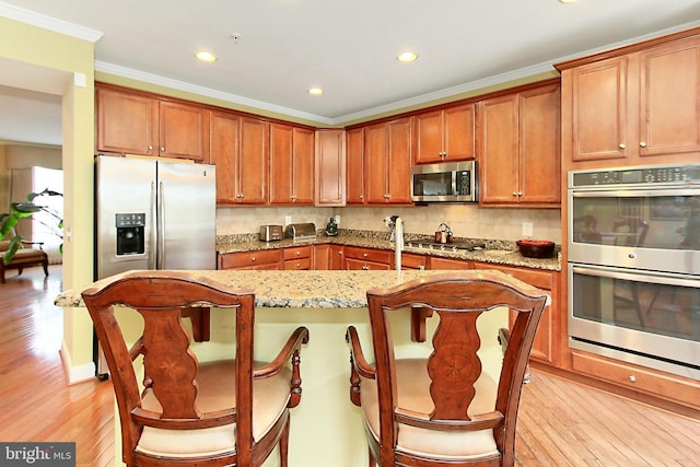 120 Fortnightly Blvd, Herndon, VA 20170 - kitchen with stainless steel appliances, light wood finished floors, a center island, light stone counters, and recessed lighting