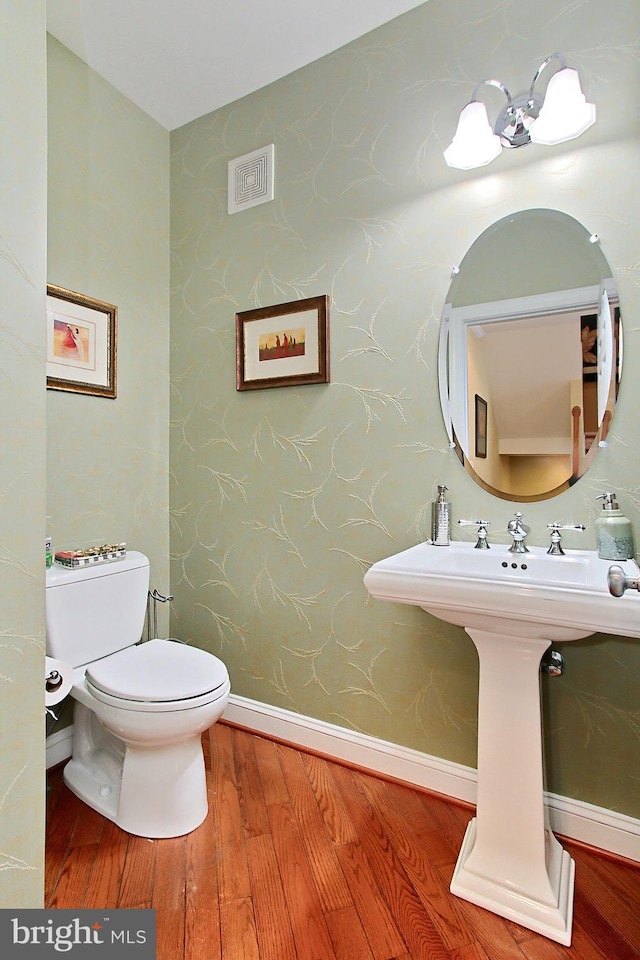 120 Fortnightly Blvd, Herndon, VA 20170 - half bathroom featuring wood finished floors, toilet, wallpapered walls, and baseboards
