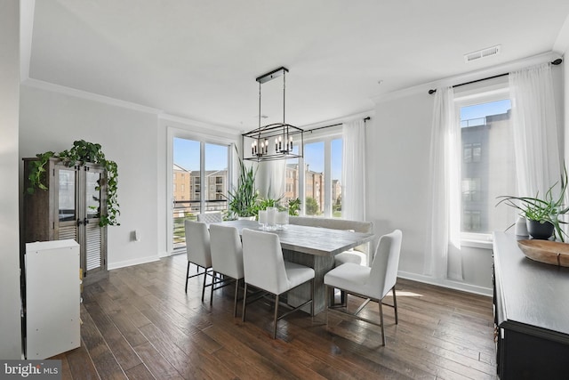 dining space with crown molding, a chandelier, dark wood-style flooring, and baseboards