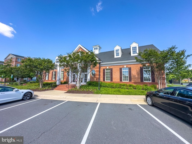 view of front of home featuring uncovered parking and brick siding