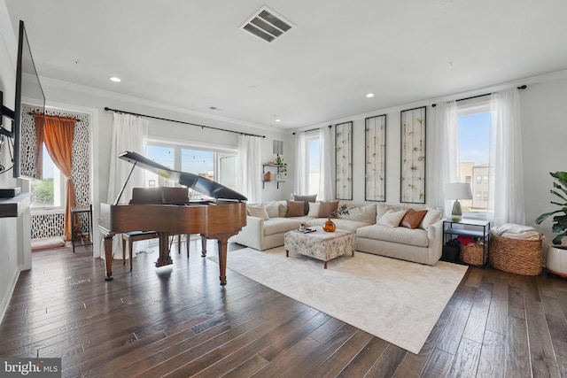 living room with dark wood finished floors, crown molding, and recessed lighting
