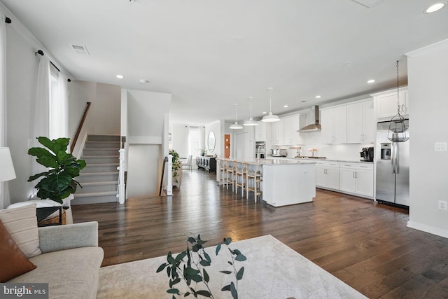 living area with dark wood-style flooring, recessed lighting, and stairway