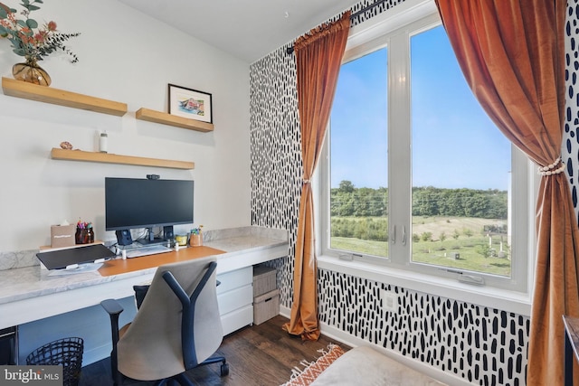 office featuring built in desk, healthy amount of natural light, and dark wood-style floors