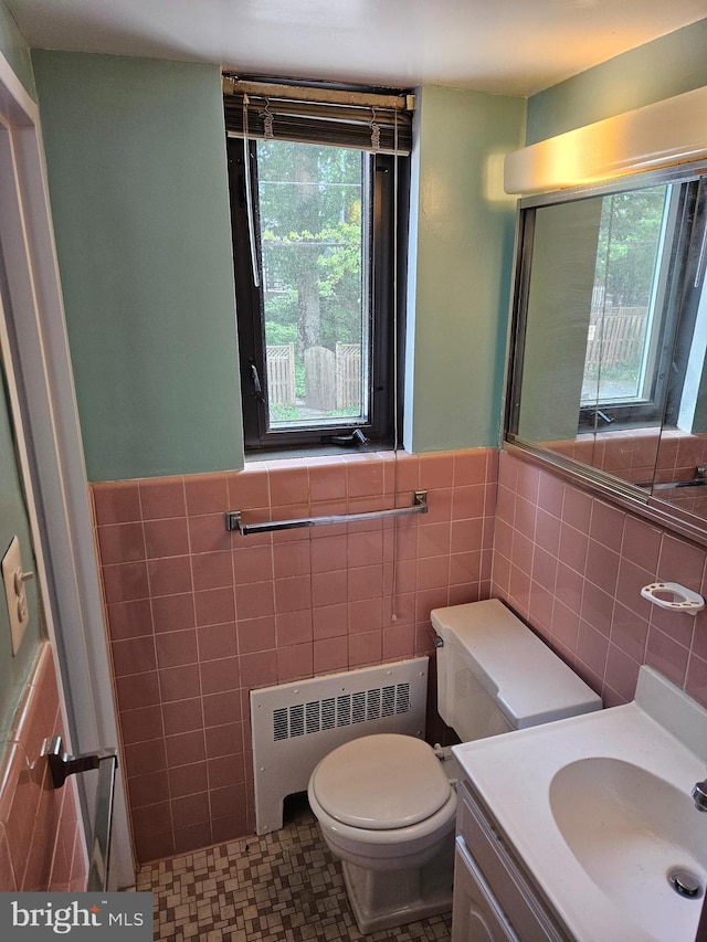 5410 Connecticut Ave NW Unit 112, Washington, DC 20015 - bathroom featuring tile walls, radiator, plenty of natural light, toilet, and a wainscoted wall