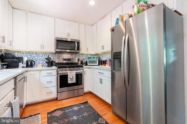 618 Chapelgate Dr, Odenton, MD 21113 - kitchen with stainless steel appliances, light countertops, light wood-style floors, white cabinets, and recessed lighting
