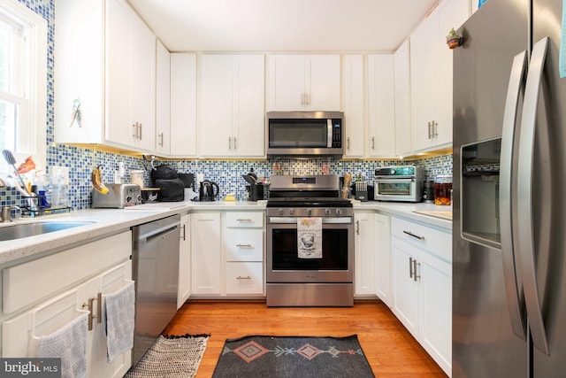 618 Chapelgate Dr, Odenton, MD 21113 - kitchen featuring stainless steel appliances, light countertops, light wood-style floors, and tasteful backsplash