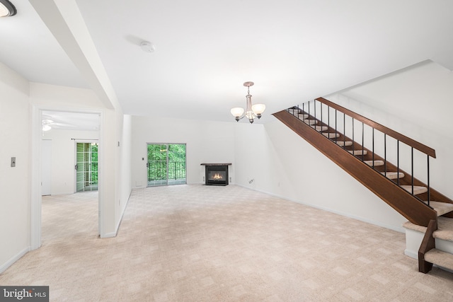 355 Westridge Cir Unit 128, Phoenixville, PA 19460 - unfurnished living room with a glass covered fireplace, light carpet, stairs, a chandelier, and ceiling fan
