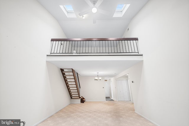 355 Westridge Cir Unit 128, Phoenixville, PA 19460 - unfurnished living room with a skylight, carpet, a chandelier, high vaulted ceiling, and stairs