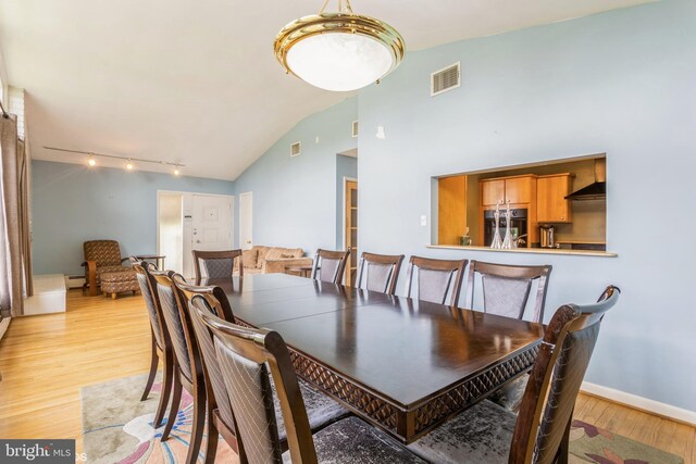 2400 Willow Glen Dr, Baltimore, MD 21209 - dining space featuring light wood-type flooring, vaulted ceiling, track lighting, and baseboard heating