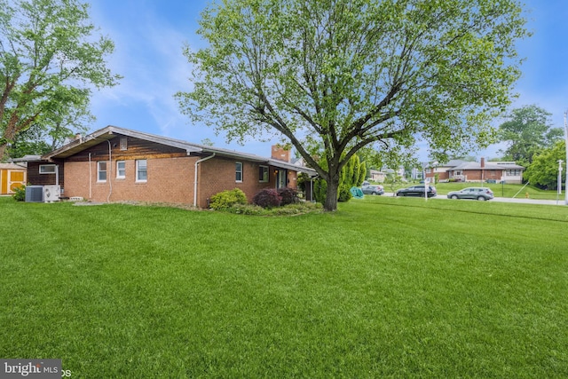 2400 Willow Glen Dr, Baltimore, MD 21209 - view of side of property with a chimney, brick siding, a lawn, and central AC unit