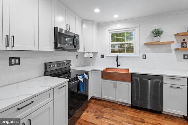 9761 Turnbuckle Dr, Burke, VA 22015 - kitchen with appliances with stainless steel finishes, a sink, tasteful backsplash, wood finished floors, and recessed lighting