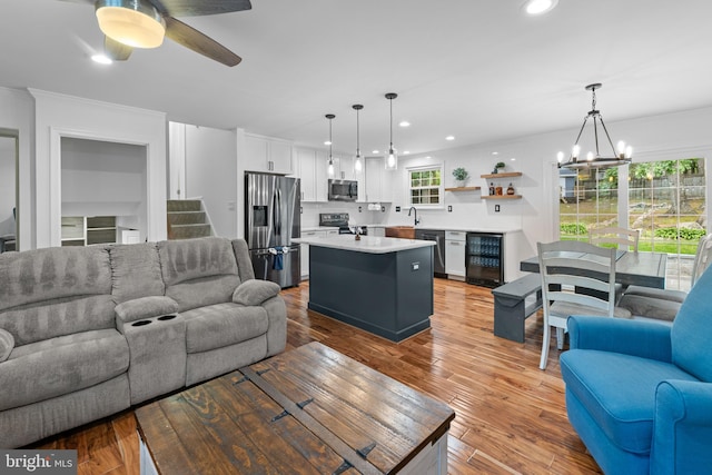 9761 Turnbuckle Dr, Burke, VA 22015 - living area with wine cooler, a chandelier, recessed lighting, ceiling fan, and crown molding