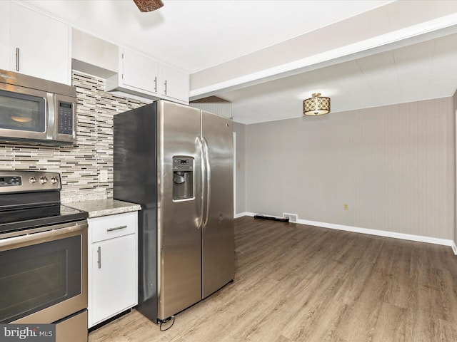 510 E Main St, Emmitsburg, MD 21727 - kitchen with appliances with stainless steel finishes, light wood-style floors, decorative backsplash, and white cabinetry