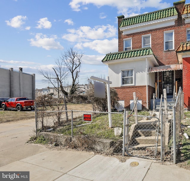 3532 Lucille Ave, Baltimore, MD 21215 - view of front of house featuring brick siding, board and batten siding, a fenced front yard, and a gate