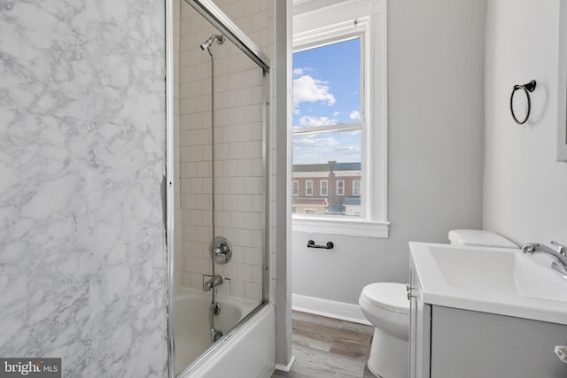 3532 Lucille Ave, Baltimore, MD 21215 - bathroom featuring toilet, shower / bath combination with glass door, wood finished floors, vanity, and baseboards