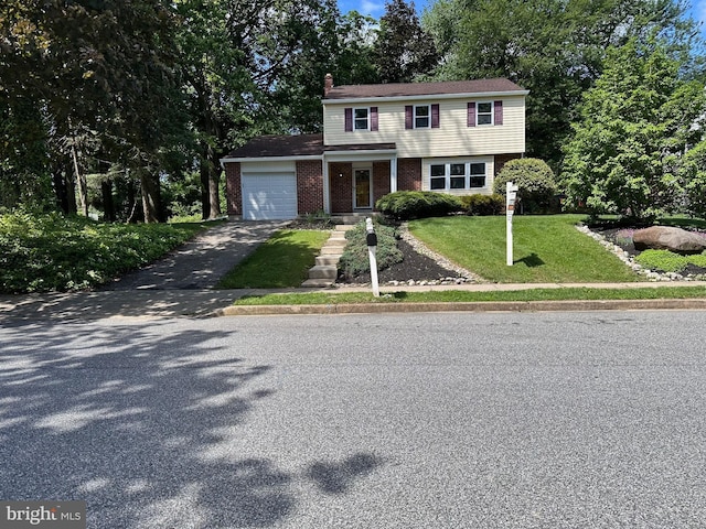 215 Bridge Rd, Upper Chichester, PA 19061 - colonial house featuring asphalt driveway, a garage, brick siding, a chimney, and a front yard