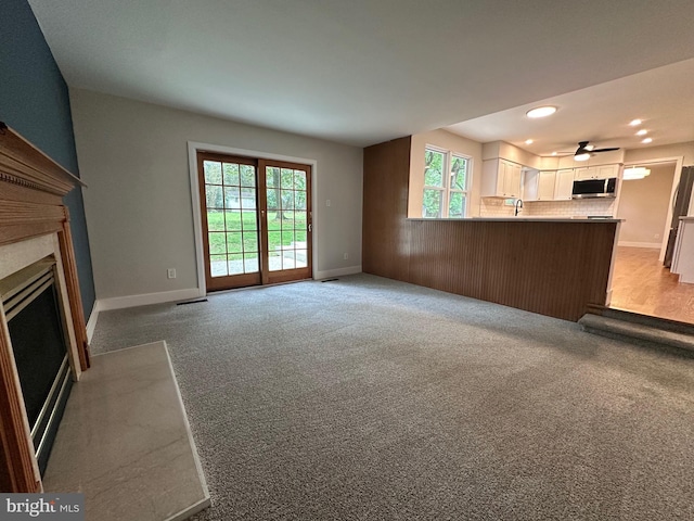 215 Bridge Rd, Upper Chichester, PA 19061 - unfurnished living room with a high end fireplace, light carpet, baseboards, recessed lighting, and a ceiling fan