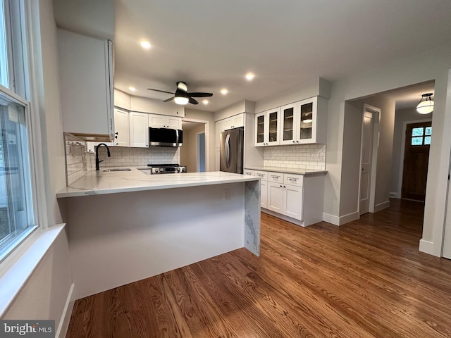 215 Bridge Rd, Upper Chichester, PA 19061 - kitchen with stainless steel appliances, a sink, a peninsula, glass insert cabinets, and backsplash