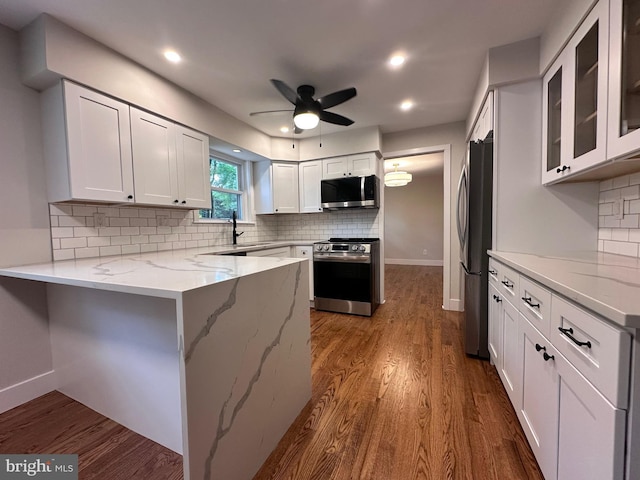 215 Bridge Rd, Upper Chichester, PA 19061 - kitchen featuring appliances with stainless steel finishes, a peninsula, ceiling fan, white cabinets, and light stone countertops