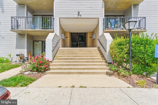 view of exterior entry with a balcony