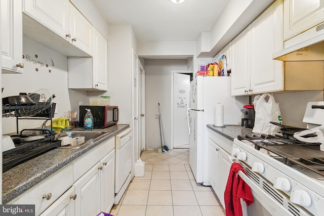 kitchen with white appliances, under cabinet range hood, white cabinets, and light tile patterned floors