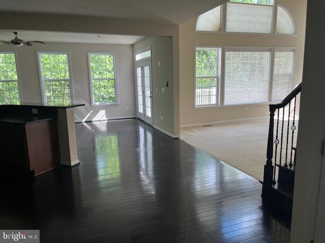 foyer featuring baseboards, a ceiling fan, and dark wood-style flooring
