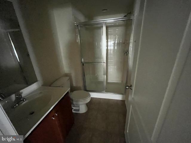 full bath featuring a stall shower, toilet, and vanity