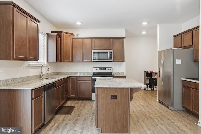 11041 Lee St, King George, VA 22485 - kitchen featuring stainless steel appliances, a sink, light wood finished floors, a kitchen island, and light stone countertops