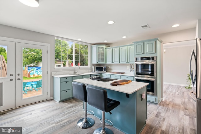 9235 Stephanie St, Manassas Park, VA 20111 - kitchen featuring stainless steel appliances, a sink, a kitchen island, recessed lighting, and light wood-style floors