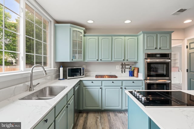9235 Stephanie St, Manassas Park, VA 20111 - kitchen with appliances with stainless steel finishes, a sink, wood finished floors, green cabinets, and recessed lighting