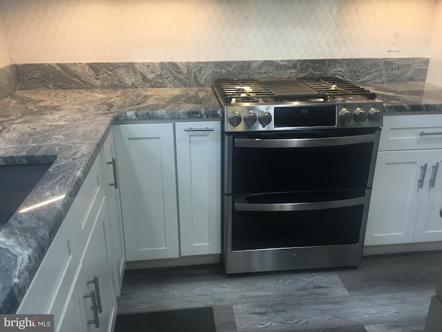7709 Gromwell Ct, Springfield, VA 22152 - kitchen view of double oven range, dark wood-style flooring, backsplash, and dark stone counters