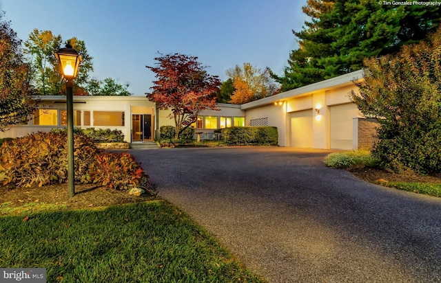 3500 Woodvalley Dr, Baltimore, MD 21208 - view of front of property featuring asphalt driveway, an attached garage, and stucco siding