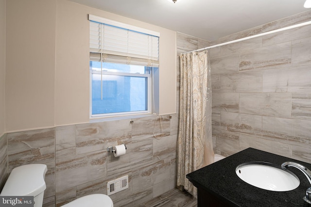 1531 Swain St, Philadelphia, PA 19130 - full bath featuring tile walls, toilet, a shower with curtain, vanity, and wainscoting