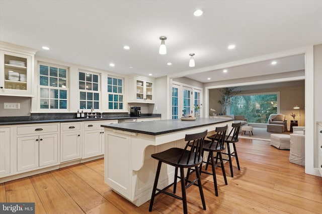 2320 Turk Rd, Doylestown, PA 18901 - kitchen featuring a center island, dark countertops, open floor plan, a kitchen bar, and white cabinetry