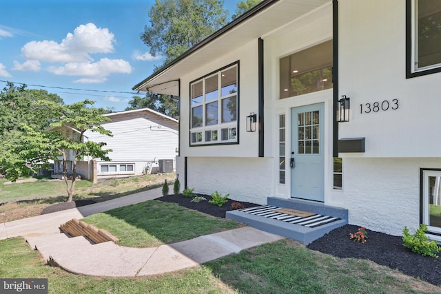 13803 Lionel Ln, Rockville, MD 20853 - doorway to property with brick siding, a lawn, and central AC