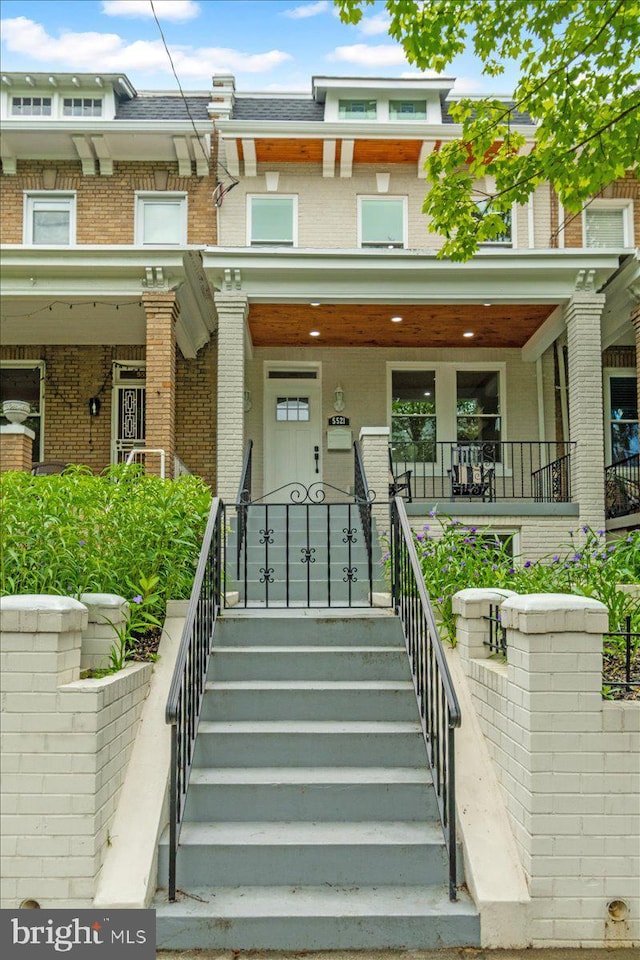 5521 4th St NW, Washington, DC 20011 - view of front facade with covered porch, brick siding, stairway, and mansard roof