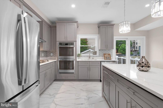 5521 4th St NW, Washington, DC 20011 - kitchen with stainless steel appliances, gray cabinets, a sink, recessed lighting, and decorative backsplash